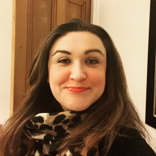 Headshot of Rachel Caldwell, a white woman with long brown hair wearing a leopard print scarf