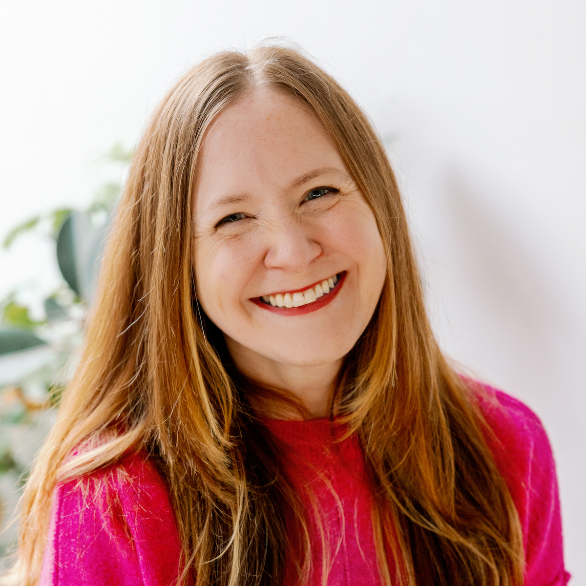 Headshot of Jen Dionisio. She has long blond hair and a pink sweater.